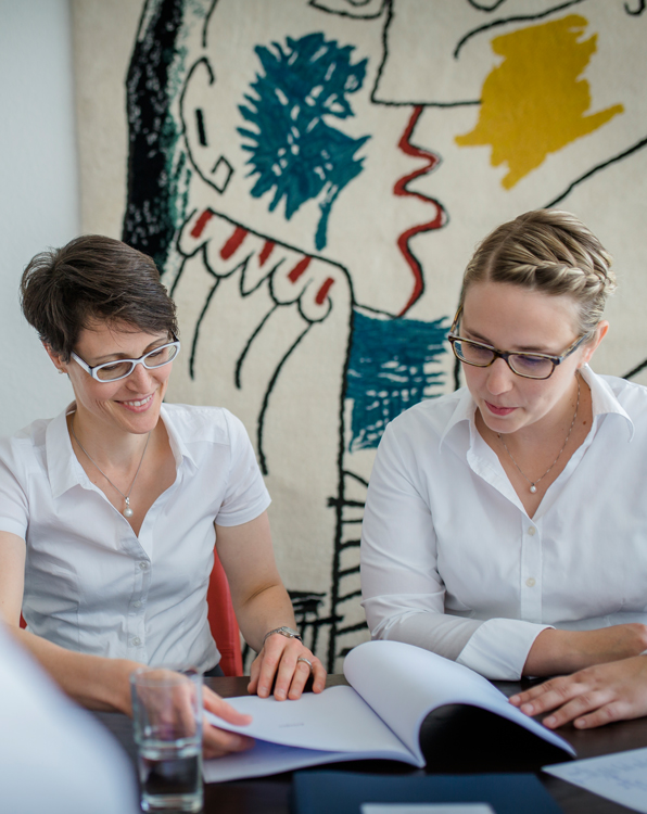 Zwei Frauen sitzen einem Tisch und besprechen sich